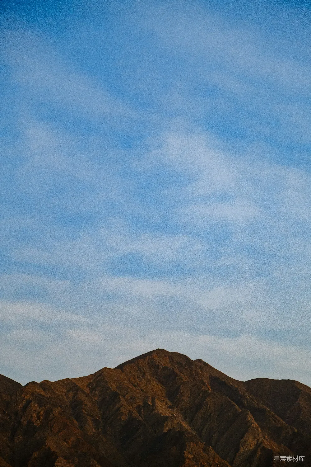 高清摄影 一架飞机在蓝天下的山峦之间飞行