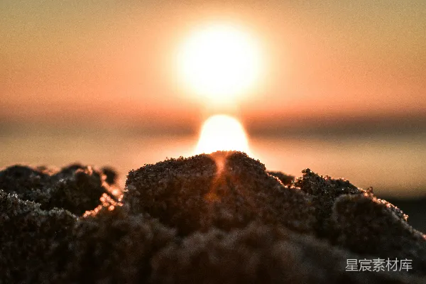 高清摄影 夕阳落下一片海滩，沙子闪烁。