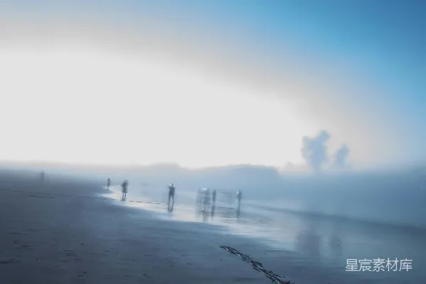 高清摄影 一群人在海边的沙滩上站立着，旁边是海洋。