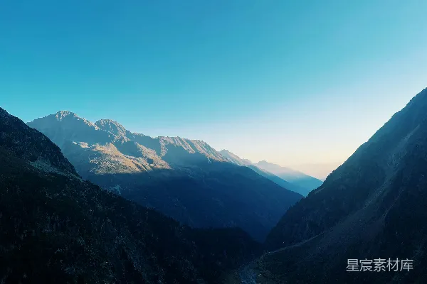 高清摄影 一幅山峦景象，其中有条河流穿过它。