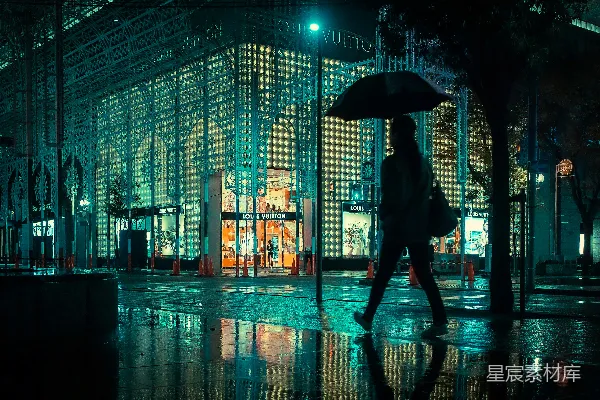 高清摄影 夜晚行人手持雨伞站在人行道上