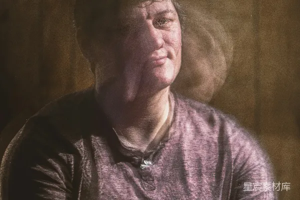 高清摄影 一个男人坐在一张木制墙壁前面抽着香烟。