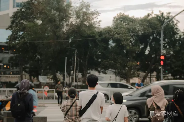 高清摄影 黄昏时分，人们在繁忙的城市街道上等待过马路。