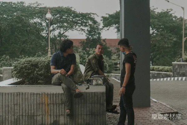 高清摄影 绿色迷彩制服的男人站在黑色T恤男人的旁边。