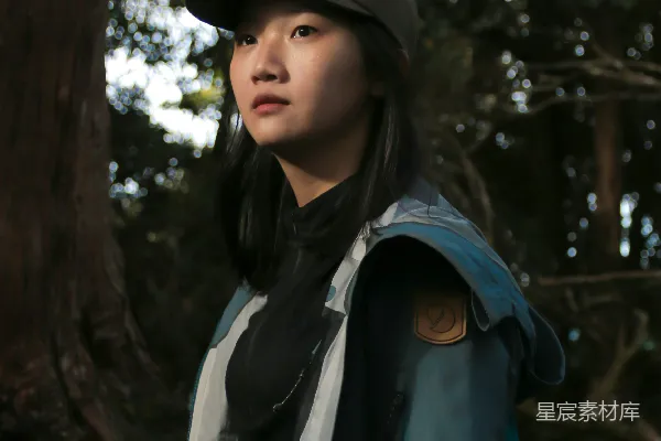 高清摄影 一个女人站在树前，戴着帽子