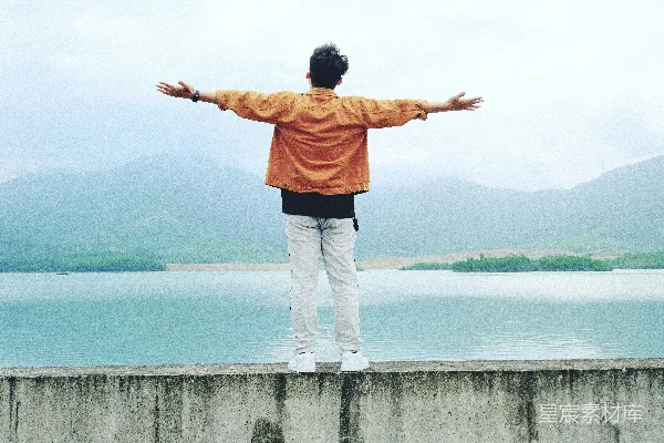 高清摄影 一个男人站在墙头，双臂伸开