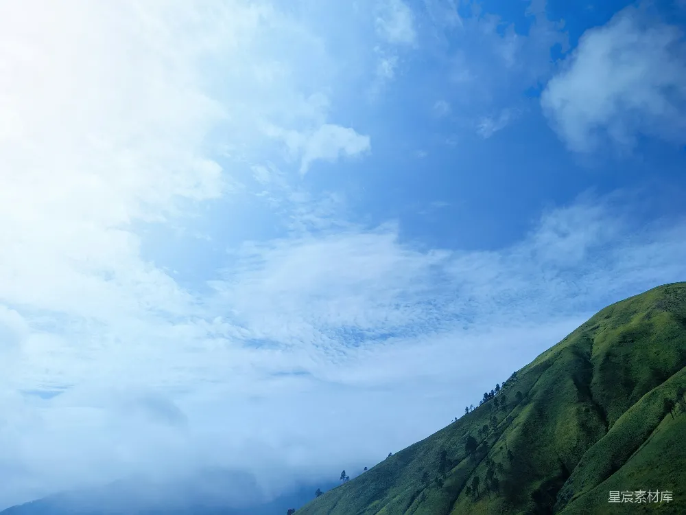 高清摄影  天空中几朵云的一座绿山