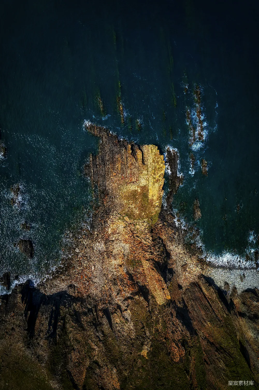 高清摄影  岩石嶙峋的悬崖下方有一片水域