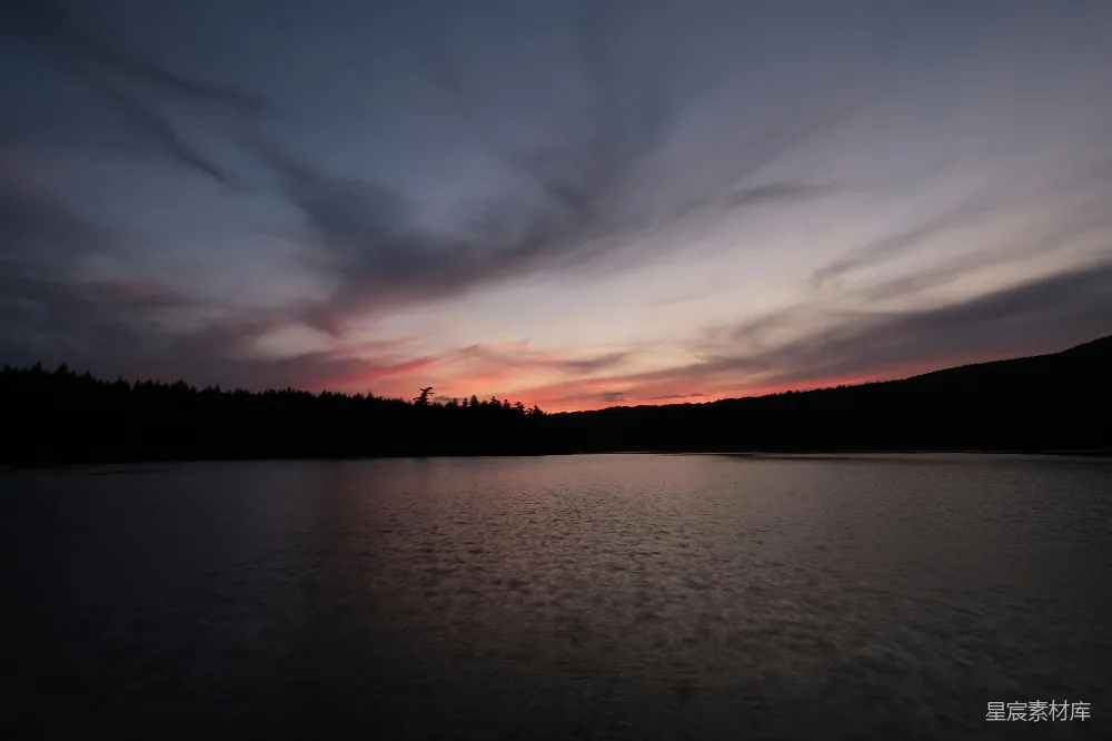 高清摄影  湖畔夕阳，背景为树木。