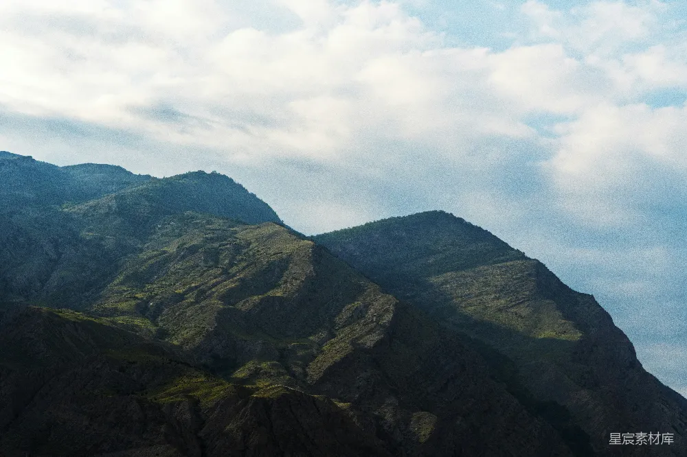 高清摄影  绿山白云间，白昼时分黑山在其中。