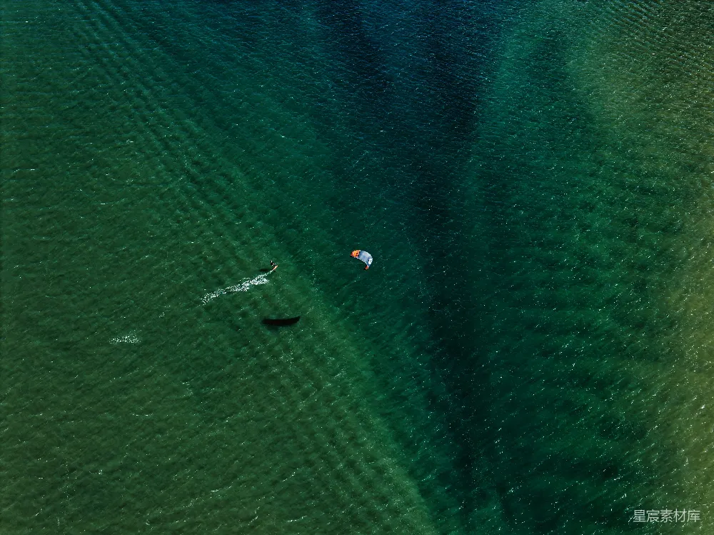 高清摄影 冲浪者在清澈的碧蓝水中滑行