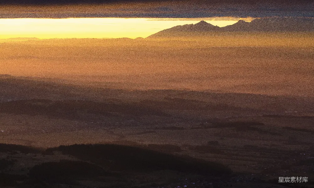 高清摄影 夕阳西下，背景是山谷中的山峦。