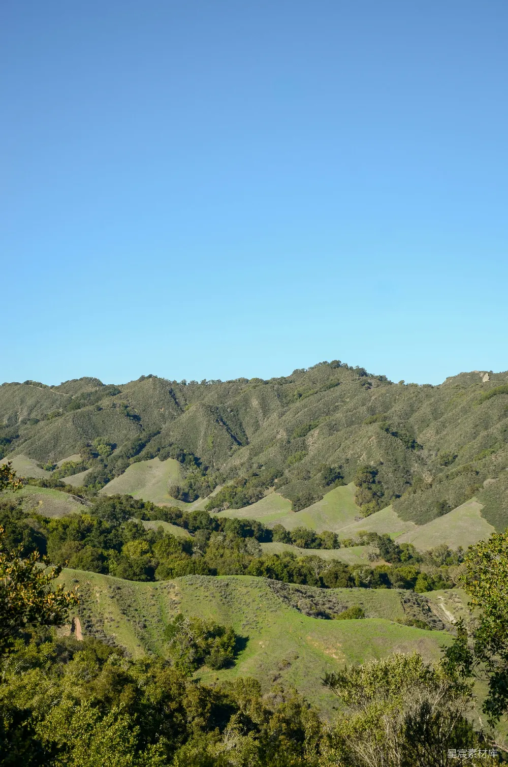 高清摄影 起伏的绿 hills 在蓝天白云下