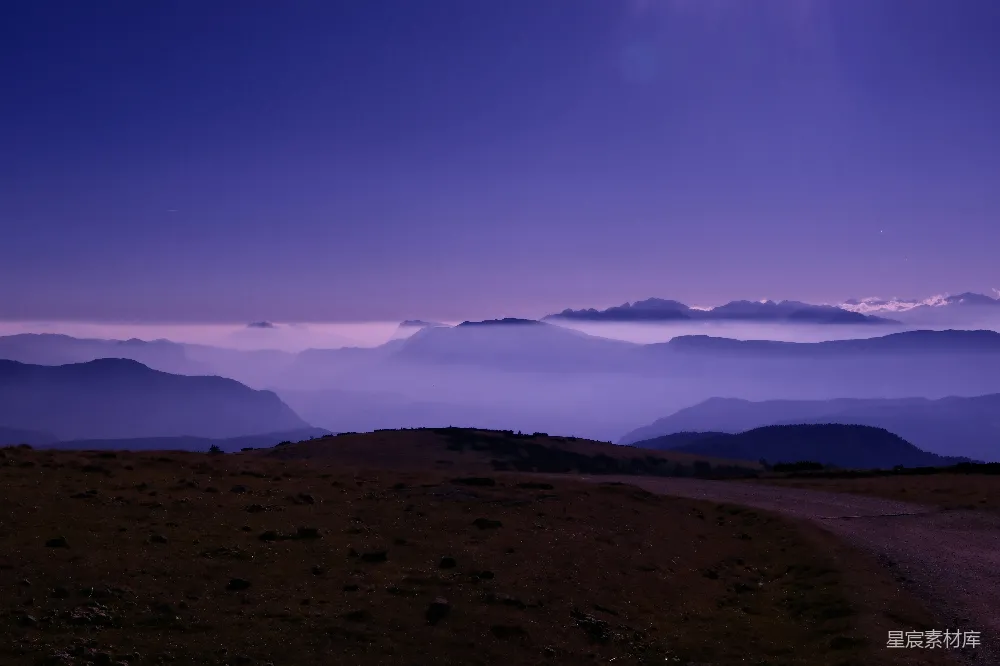 高清摄影  黎明时分远处山峦上空的紫色雾气。