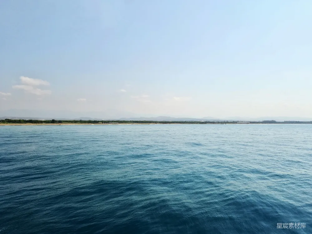 高清摄影 平静的远处未开发海岸边的浅蓝色海水
