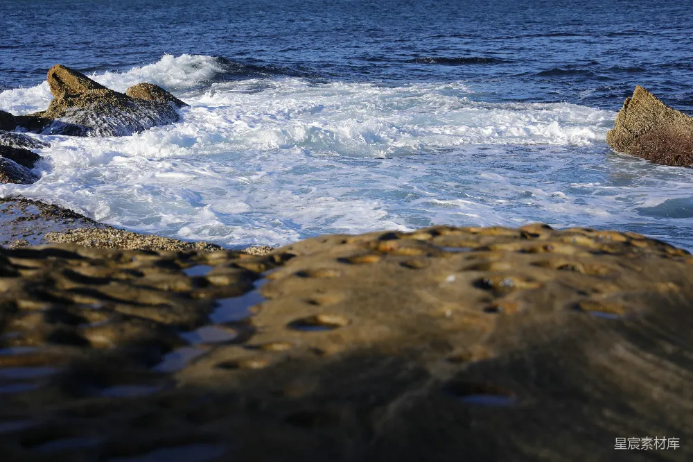 高清摄影 岩石嶙峋的海岸，波浪拍击着岩石。