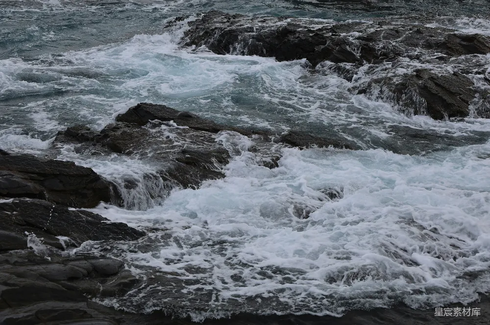 高清摄影  波浪冲刷着黑暗的岩石海岸。