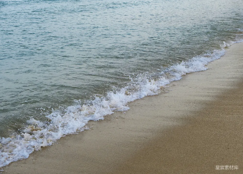 高清摄影 一片沙子覆盖的海滩，海浪涌向岸边