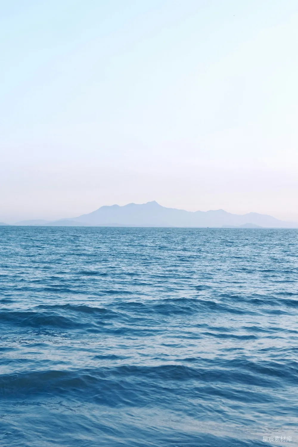 高清摄影 海边一个男子骑在海浪上的冲浪板上