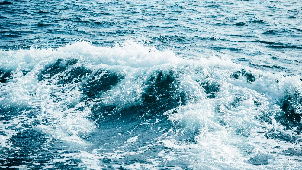 高清摄影 海浪拍打岸边，泛起白色泡沫