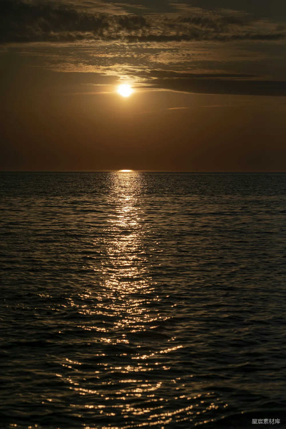 高清摄影 背景中有一片广阔的水域，夕阳西下。