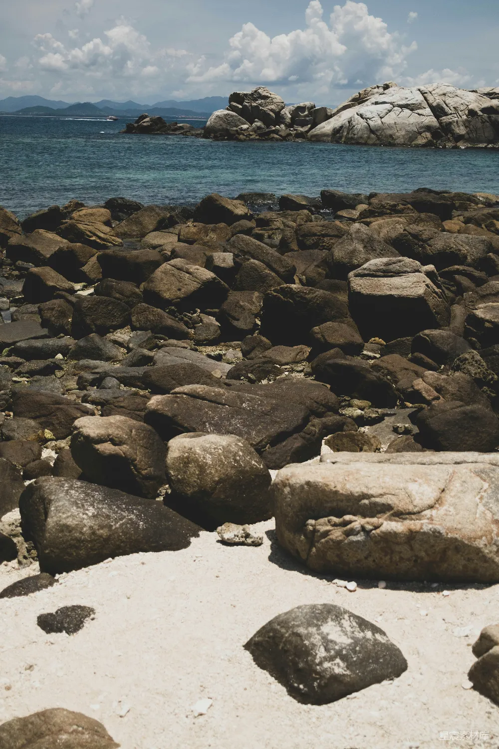 高清摄影 海滩上的岩石和沙子以及背景中的水面