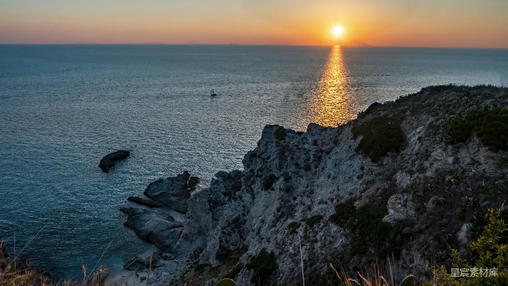 高清摄影 夕阳西下，海面上有一艘船在远处。