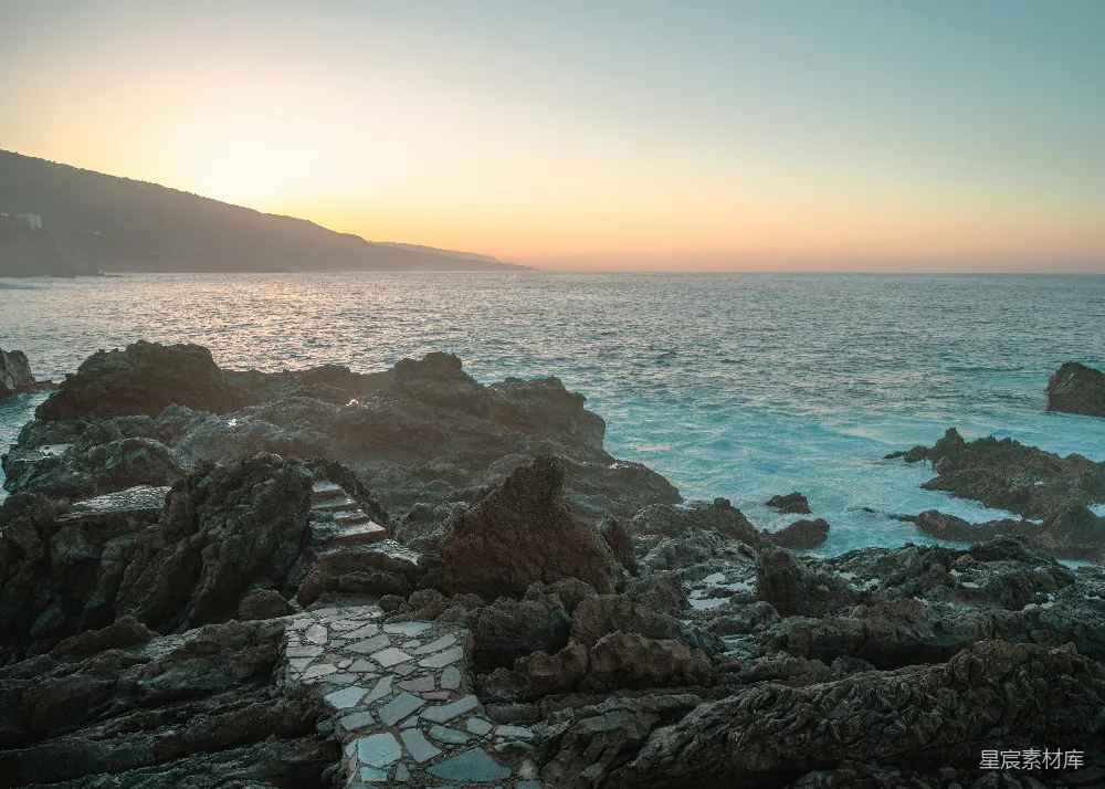 高清摄影 夕阳西下，映照着海边的岩石。