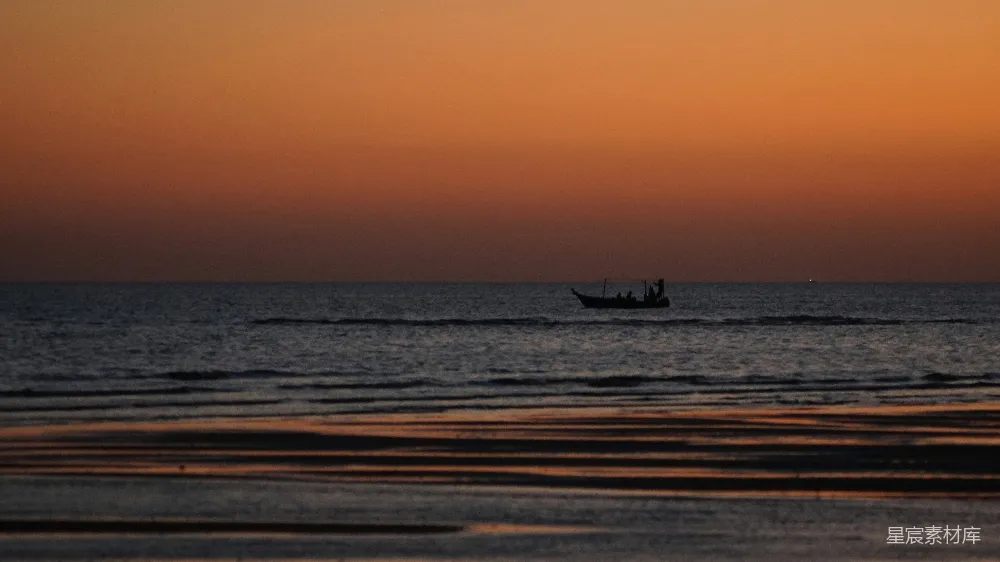 高清摄影 夕阳下船只驶过大海。