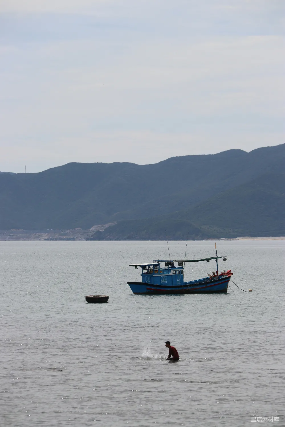 高清摄影  一艘蓝色的捕鱼船漂浮在平静的大海中。