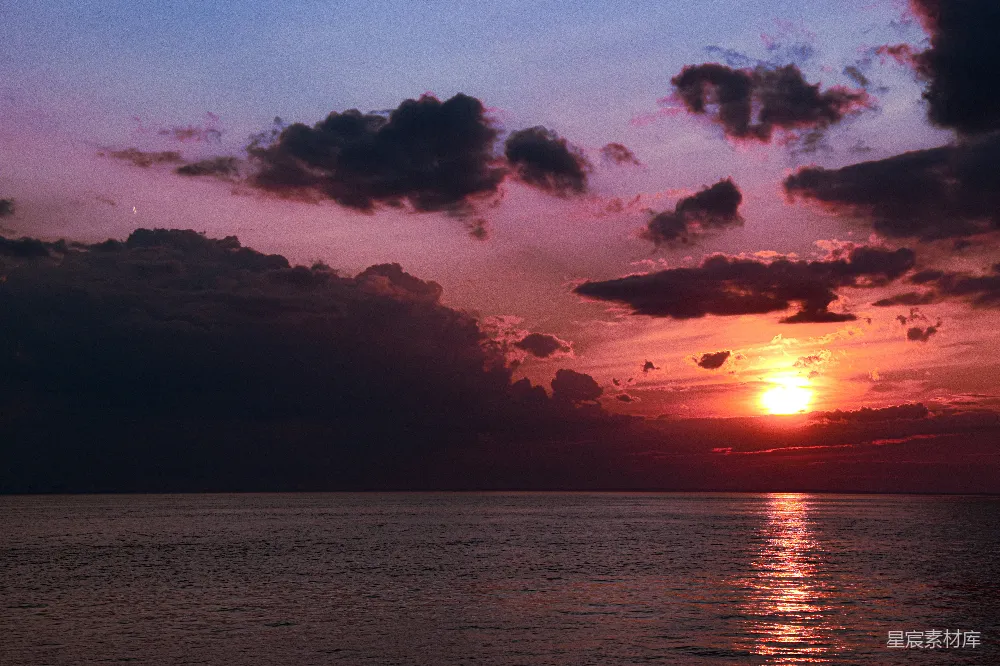高清摄影 一天 cloudy 天，夕阳西下于海面。