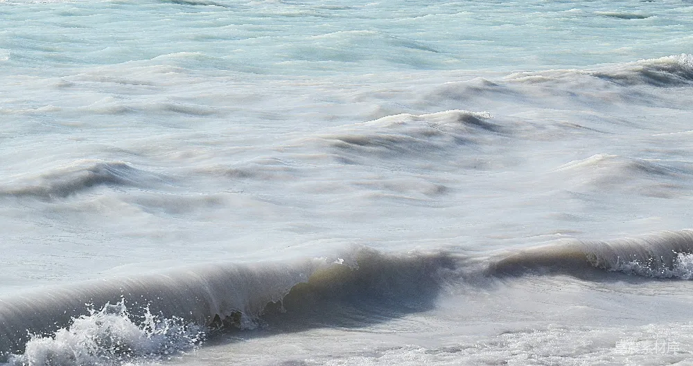 高清摄影 海边一名男子骑在波浪上的冲浪板上