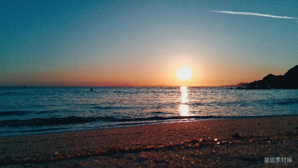 高清摄影 夕阳下的平静海洋与沙滩。