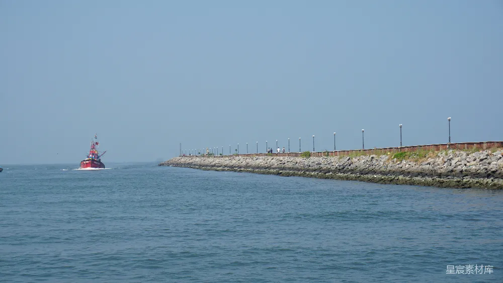 高清摄影  一片有岩石海岸和红船的水域