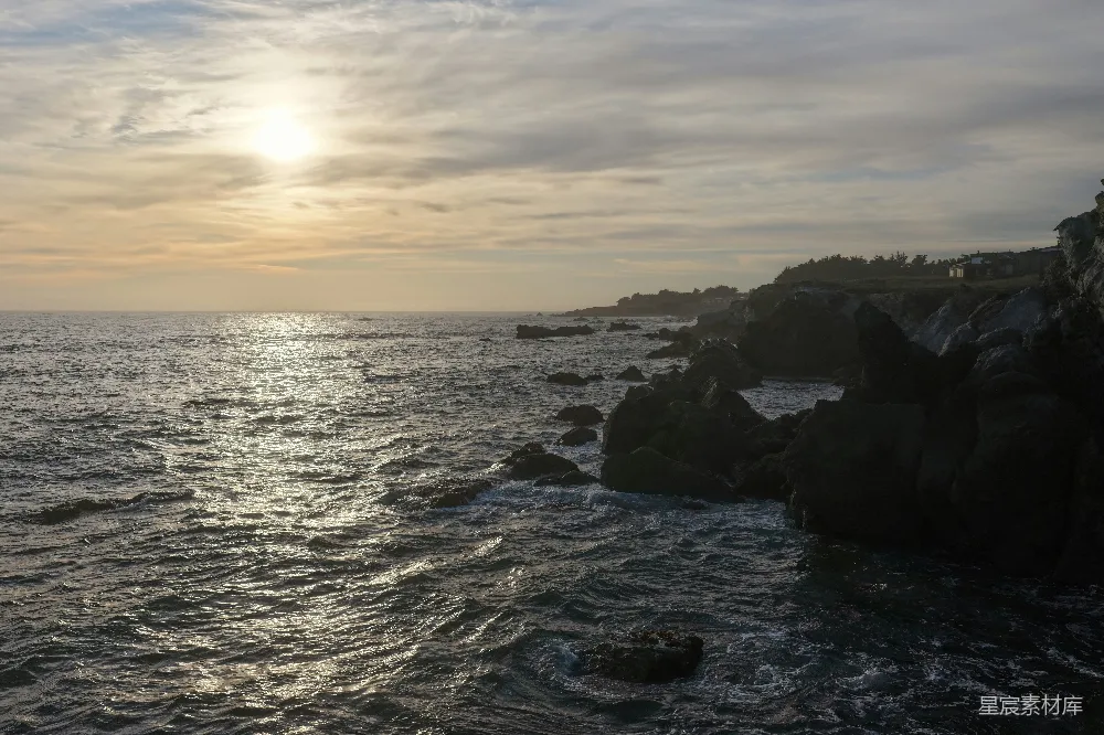 高清摄影 夕阳映照在一块岩石海岸和海洋上。