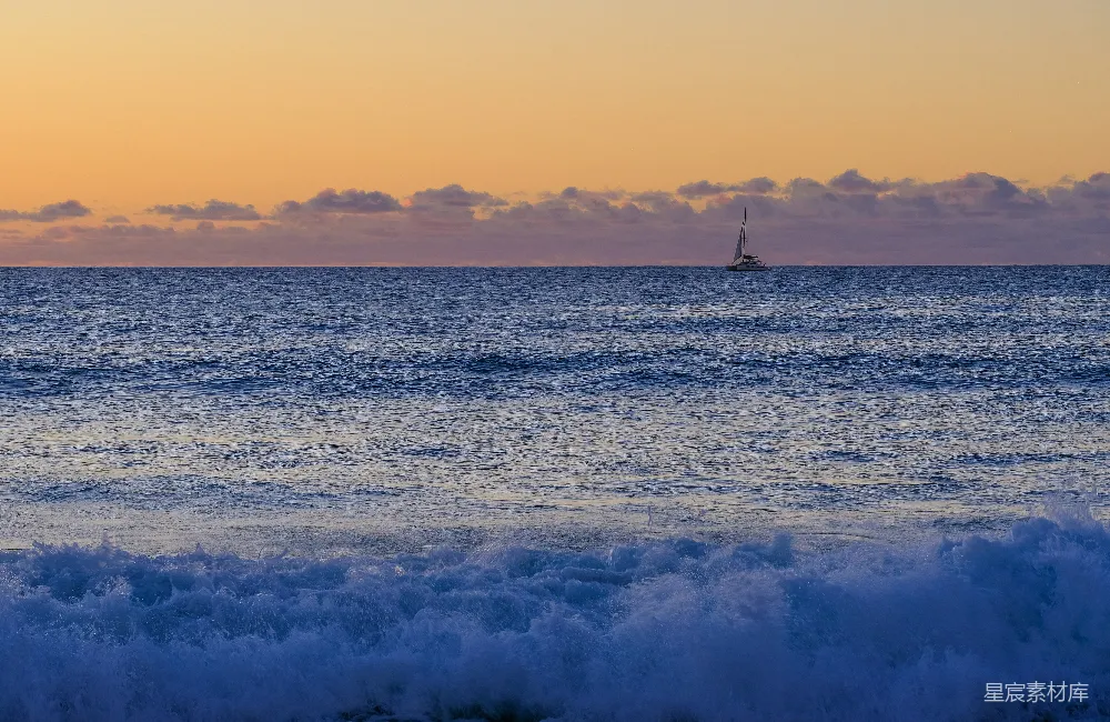 高清摄影 一艘帆船在夕阳下漂浮在海洋中