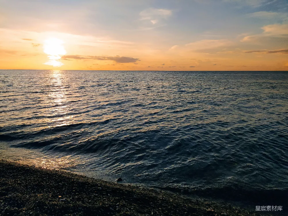 高清摄影 海滩上的水面正落下夕阳的余晖。