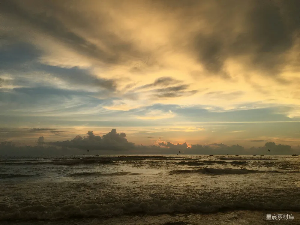 高清摄影  一天中的傍晚，天空布满了乌云，夕阳正慢慢沉入海面。