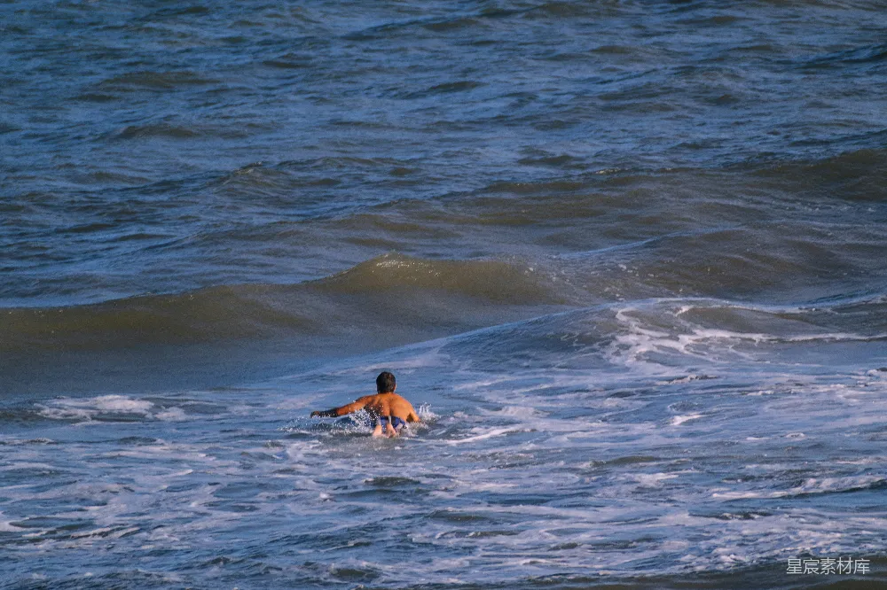 高清摄影  一个男子骑在冲浪板上 surfing于波浪之上