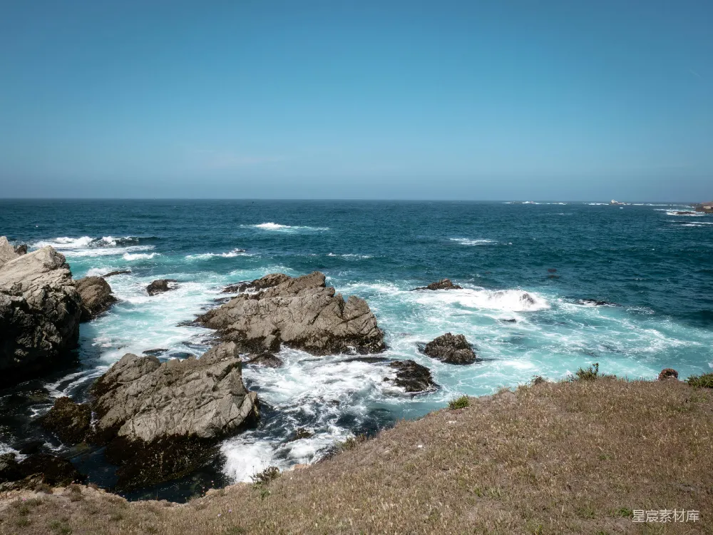 高清摄影 岩石海岸在蓝天白云下与海洋相遇。
