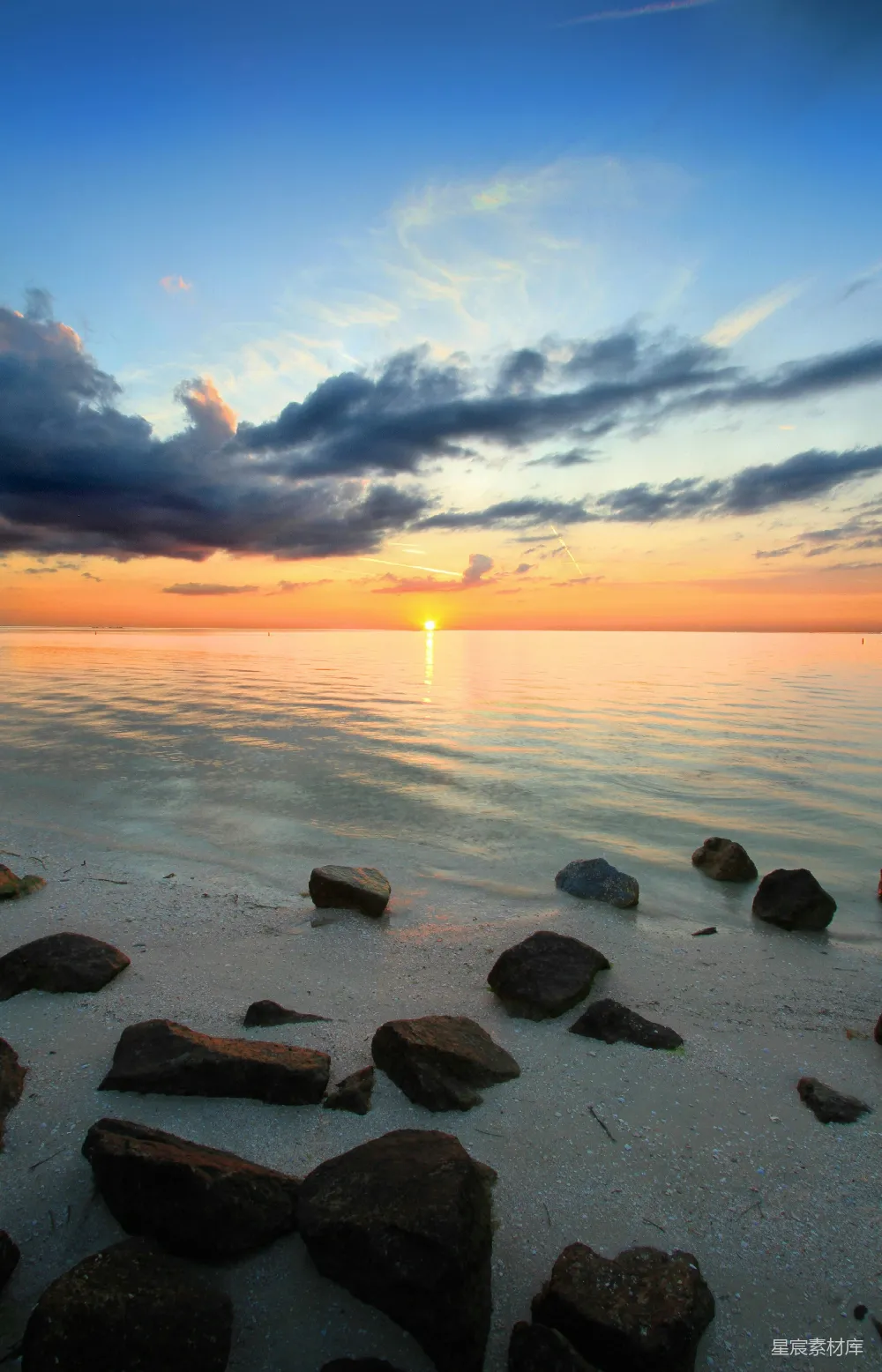 高清摄影  一片岩石突出的海滩，夕阳西下