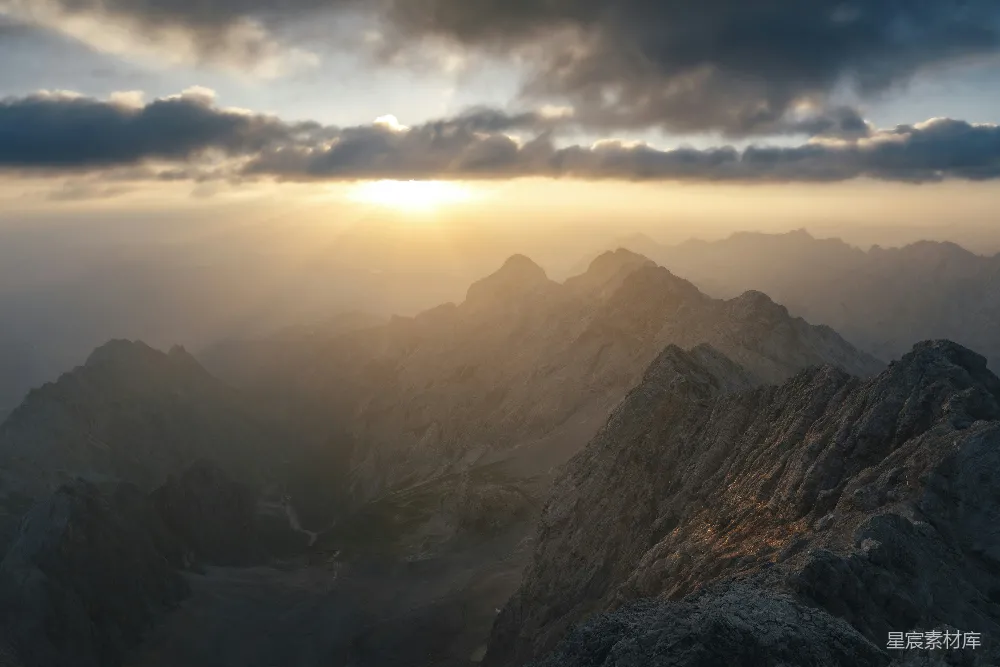 高清摄影 自然 壁纸 旅行 山峰上阳光穿透云层的缕缕光芒。