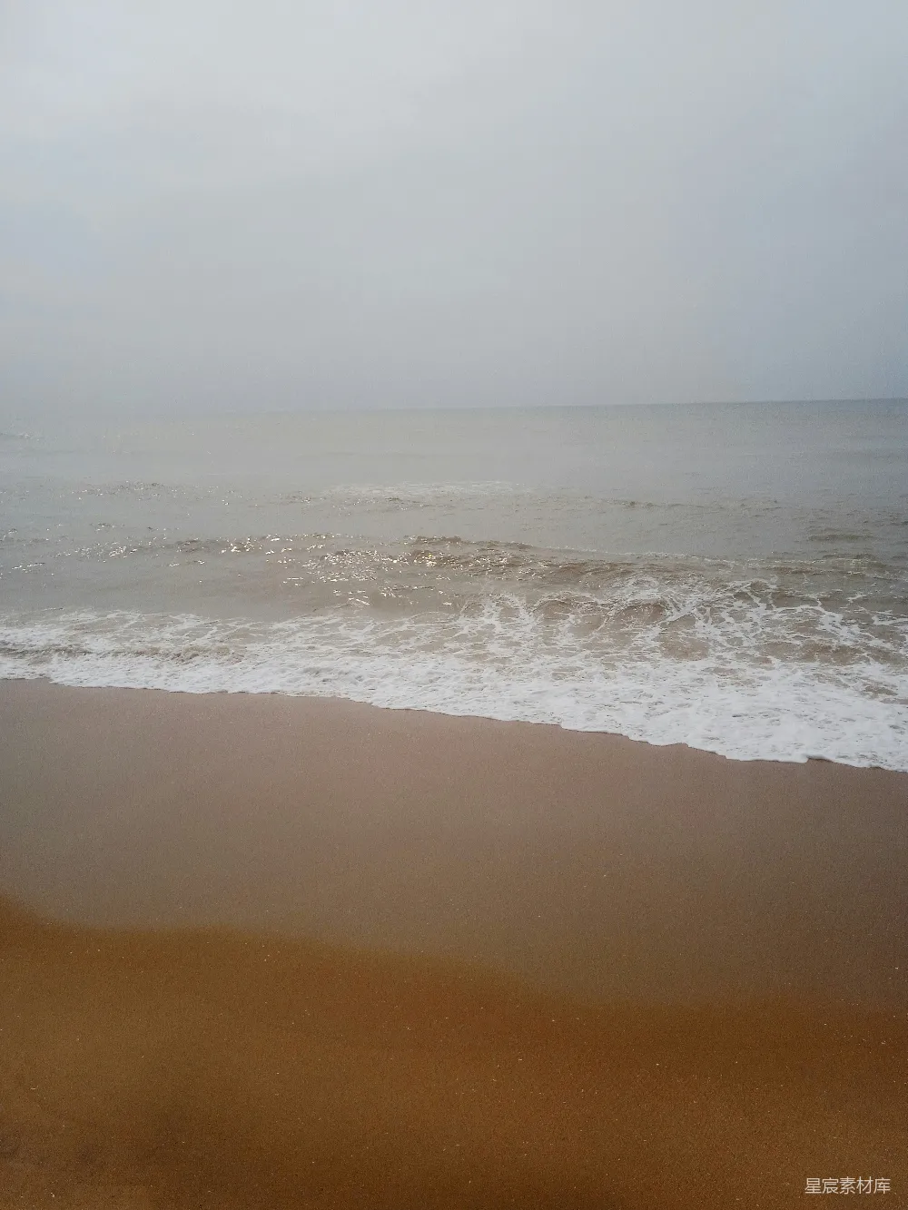 高清摄影 一片沙岸，波浪涌向岸边