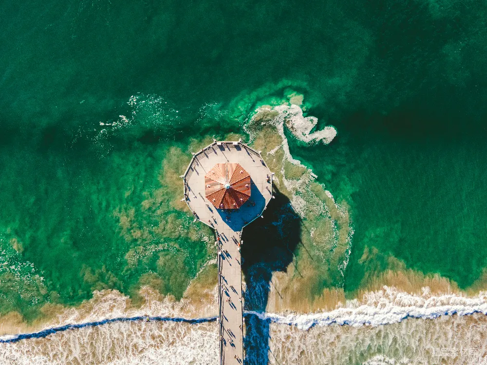 高清摄影 海滩上空的俯视图，可以看到沙滩上有遮阳伞。