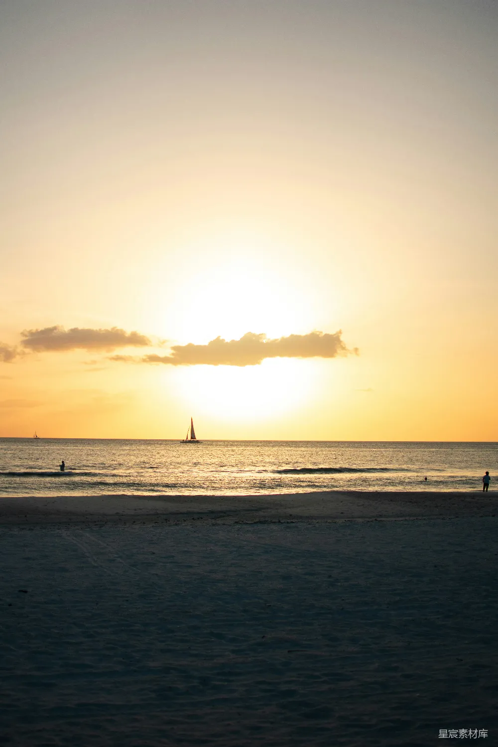 高清摄影 夕阳西下，海面上有一艘帆船在远处。