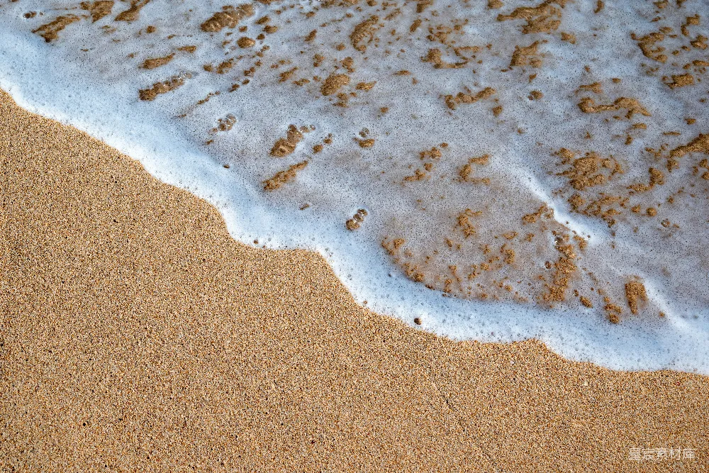 高清摄影 一片沙白的海滩，海浪涌向岸边。