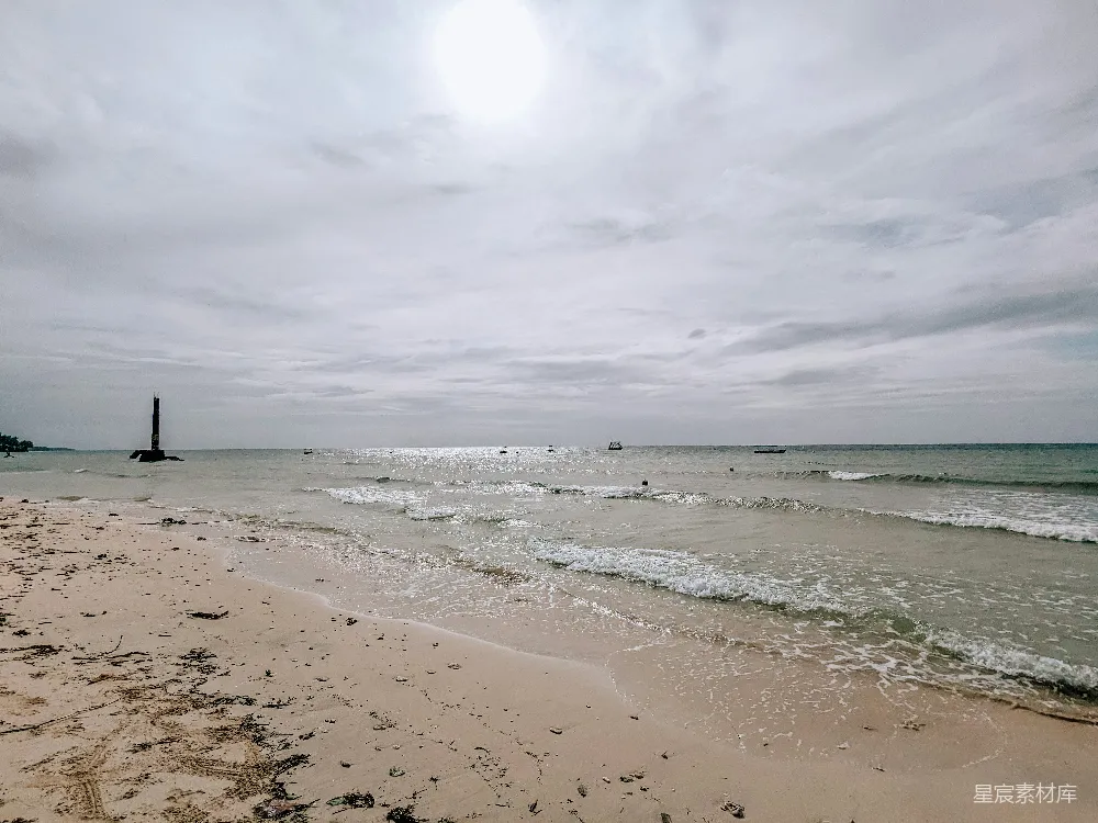 高清摄影 一片沙白的海滩，海浪涌向岸边。
