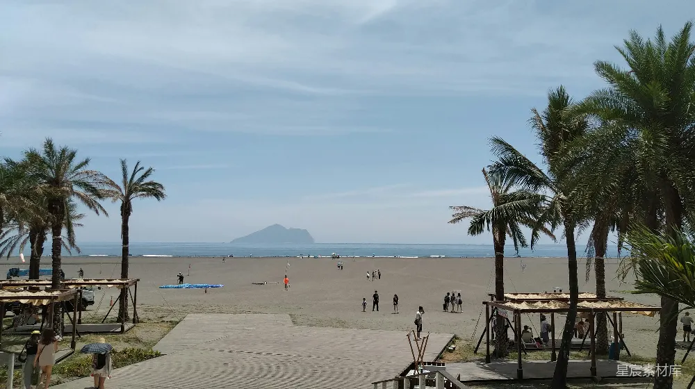 高清摄影 一棵椰子树环绕的海滩以及人们的身影