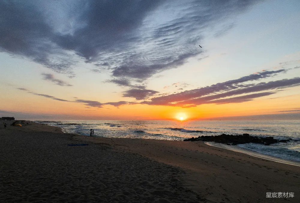 高清摄影  夕阳西下，悬挂在海边的海面上。