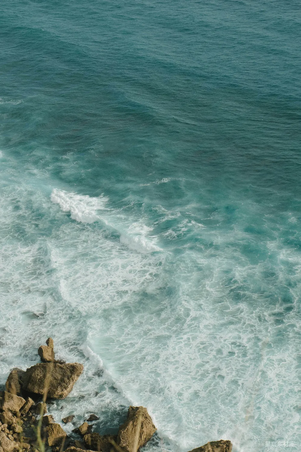 高清摄影 一个男子骑在波浪上的冲浪板上，漂浮在覆盖着海水的大海上。